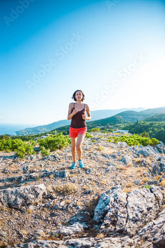A girl is running in the mountains.