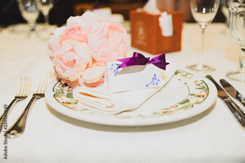 Empty classic white plate in a restaurant with a blank card and copyspace for example guest names. Empty classic white plate in a restaurant with a blank card and copyspace for example guest names.