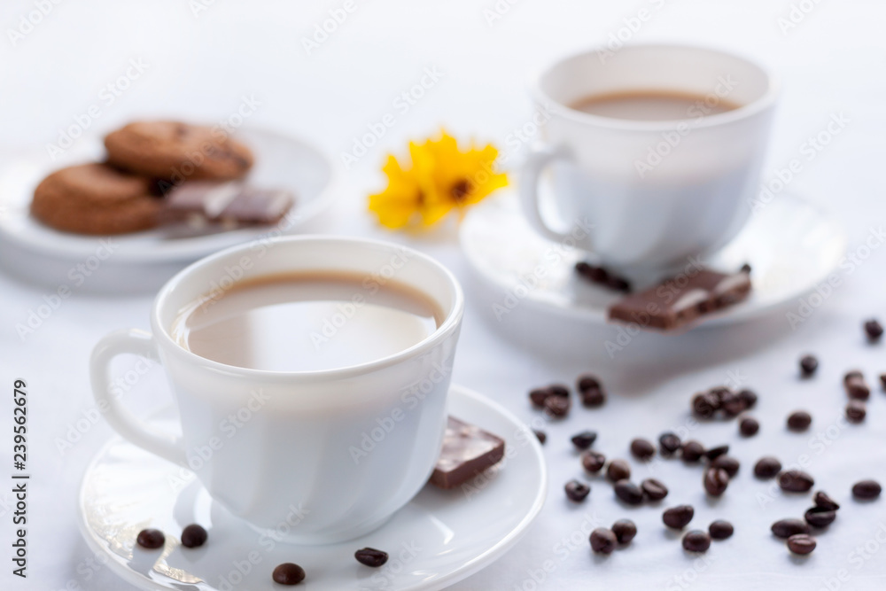 Two cup of coffee, oatmeal cookies and milk chocolate. Morning breakfast for two. Two cup of coffee, oatmeal cookies and milk chocolate. Morning breakfast for two.