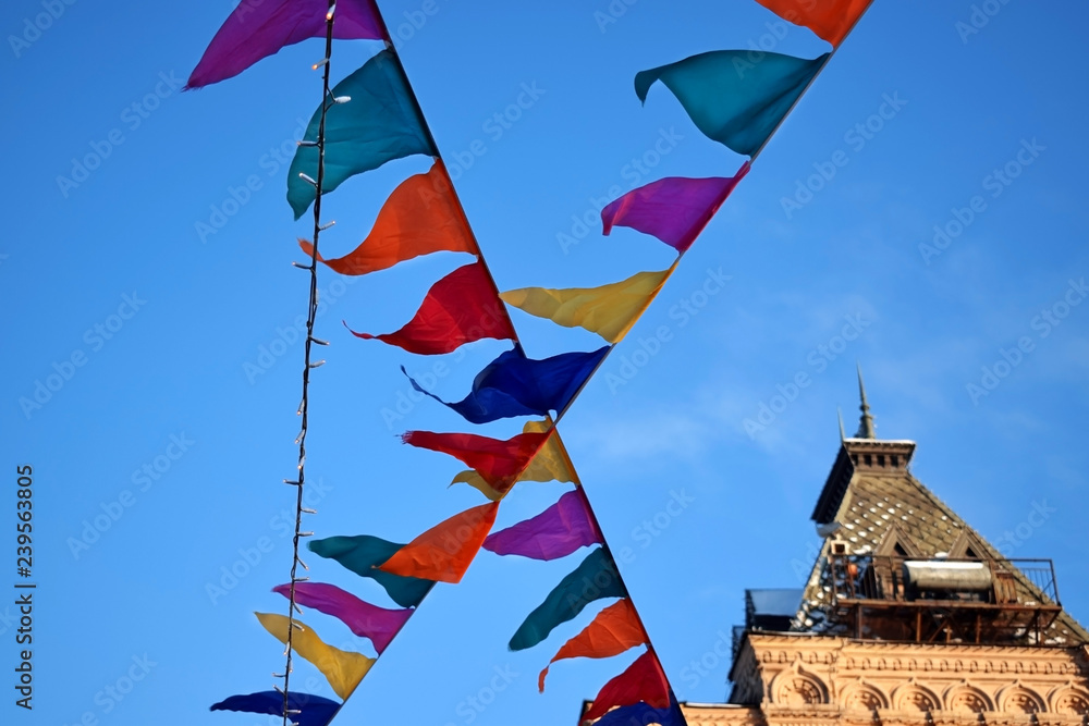 Moscow, Russia - December 16, 2018: Decorative multicoloured flags of the GUM fair against the blue sky