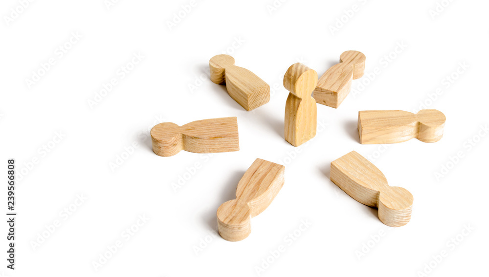 A person stands in the center of a circle of people. Leader and boss. Business team, teamwork, team spirit. Wooden figures of people. A circle of people. The concept of discussion and cooperation A person stands in the center of a circle of people. Leader and boss. Business team, teamwork, team spirit. Wooden figures of people. A circle of people. The concept of discussion and cooperation
