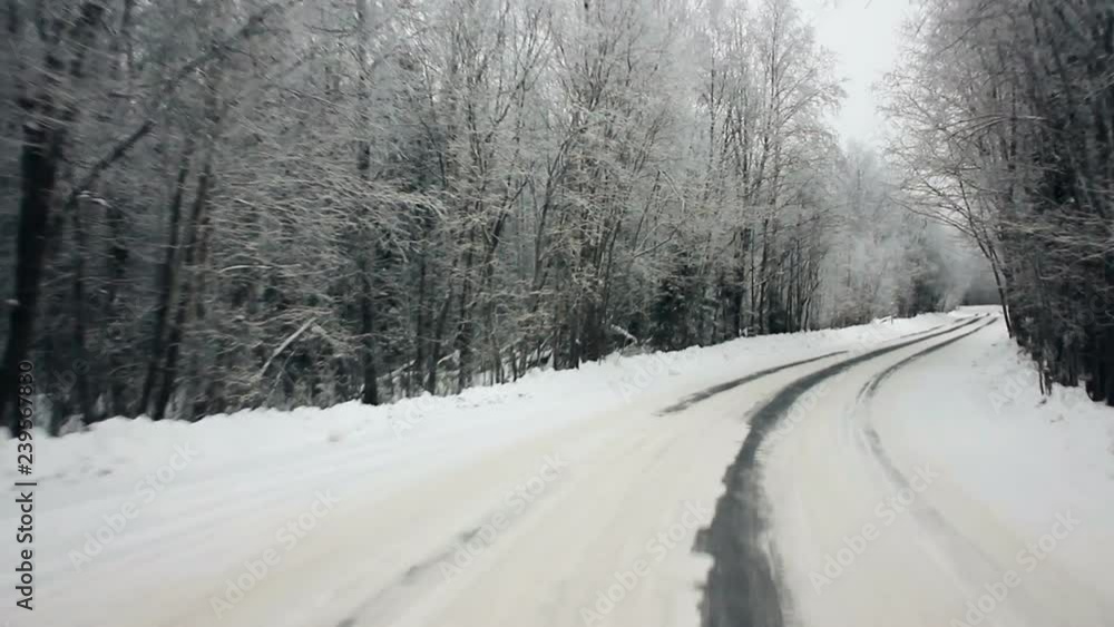 Driving through the winter forest on snowy road, first view. Camera outside the window on steadicam. Driving pov at the first snow of winter on a beautiful mountain fir forest road. Driving through the winter forest on snowy road, first view. Camera outside the window on steadicam. Driving pov at the first snow of winter on a beautiful mountain fir forest road.