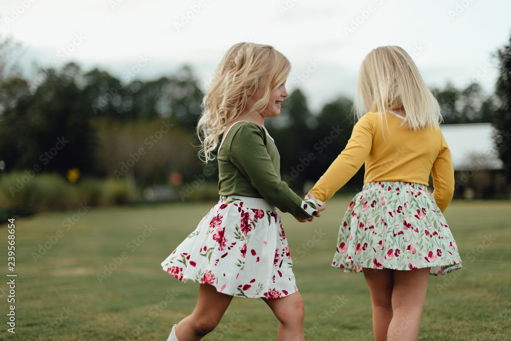 Two girls holding hands and playing Two girls holding hands and playing