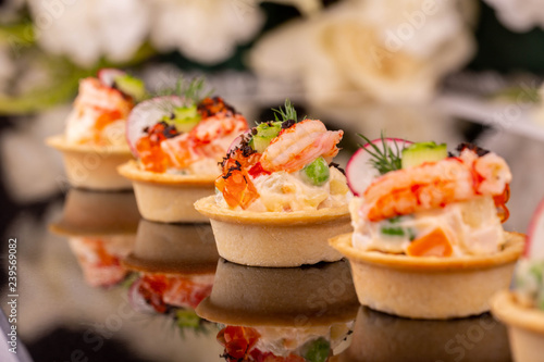 Boiled shrimps in tartlet with red caviar and vegetables with greens