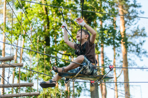 Boy passing cable route in extreme adventure rope park