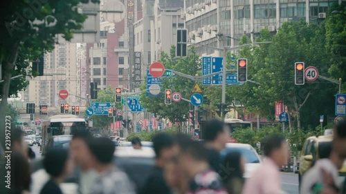 Typical crowded street in Shanghai full of people, cars and buses