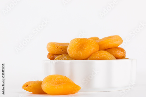 Dry Apricot in white bowl isolated on whhite background photo