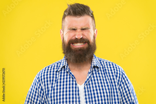 Just sneezed. Man bearded hipster with sneezing face closed eyes close up yellow background. Brutal hipster sneezing. Allergy season concept. Take allergy medications. Can not stop sneezing