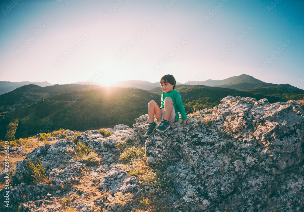 Naklejka premium A boy on top of a mountain.