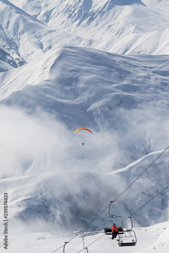 Chair-lift and paraplane in fog on ski resort Chair-lift and paraplane in fog on ski resort