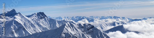Panorama of snowy mountains in clouds