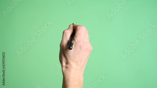 Male Hand Writing On Green Screen. Hand writing with a marker pen on a green screen background.