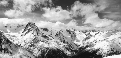 Black and white panorama of snowy winter mountain in sunlight clouds © BSANI