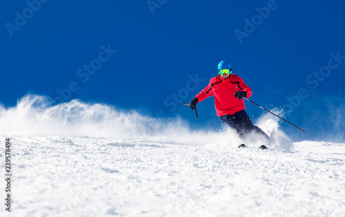 Man skiing on the prepared slope with fresh new powder snow