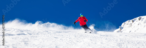 Człowiek na nartach na przygotowanym stoku ze świeżym, nowym śniegiem