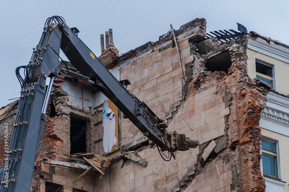 Fototapeta premium demolition of a multi-storey building with hydraulic shears, for future development of residential buildings