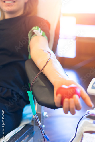 young woman as blood donor at donation with a bouncy ball holding in hand