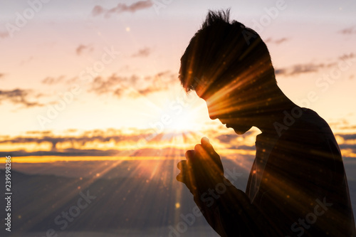 Silhouette of christian man hand praying,spirituality and religion,man praying to god. Christianity concept. photo