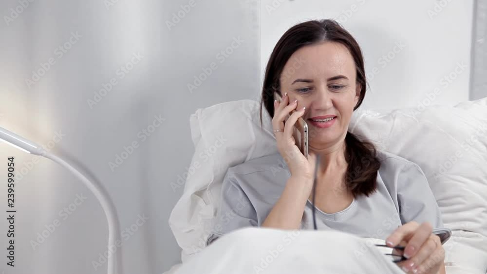 Female Patient Using Mobile Phone In Hospital Bed Female Patient Using Mobile Phone In Hospital Bed