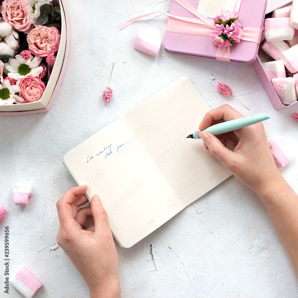 Girl writes in open notebook on table with flowers and marshmallows,pastel  colors.Beauty Flat lay.Copy space.Eye bird view. foto de Stock | Adobe Stock