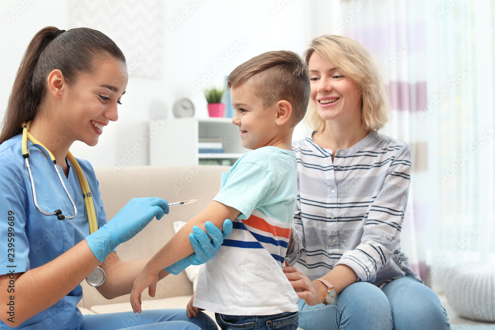 Obraz premium Children's doctor vaccinating little boy at home