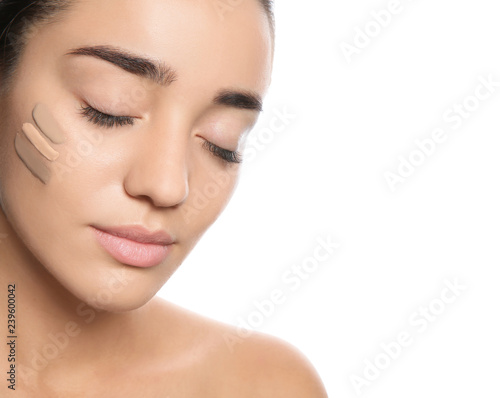 Young woman with different shades of skin foundation on her face against white background
