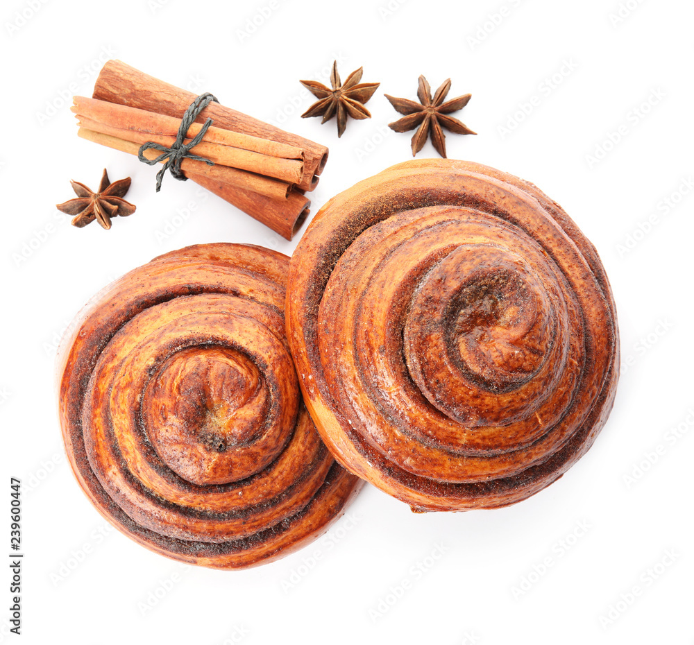 Freshly baked cinnamon rolls with ingredients on white background, top view