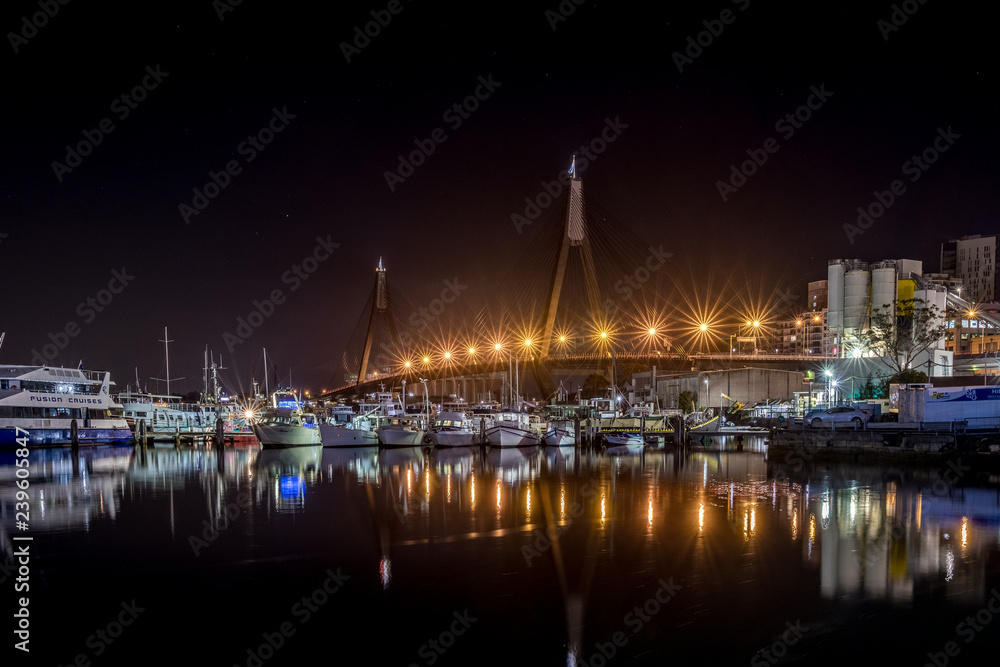 Fishing boats and a bridge at night