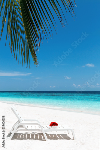 Santa hat on chair with palm leaves on background