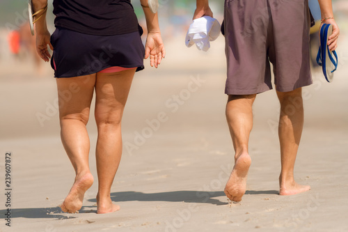 Legs of older couple walking on Copacabana beach in Rio de Janeiro (Brazil)