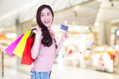 Happy beautiful Asian women enjoy shopping and holding credit card on shopping mall background, Shopaholic, Buy during the year-end promotion, special offer price mid-year, Consumerism woman lifestyle