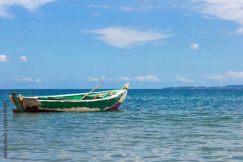 Boat on a beautiful beach of blue and green water