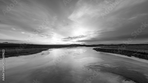 Black and white sunset reflected over ice