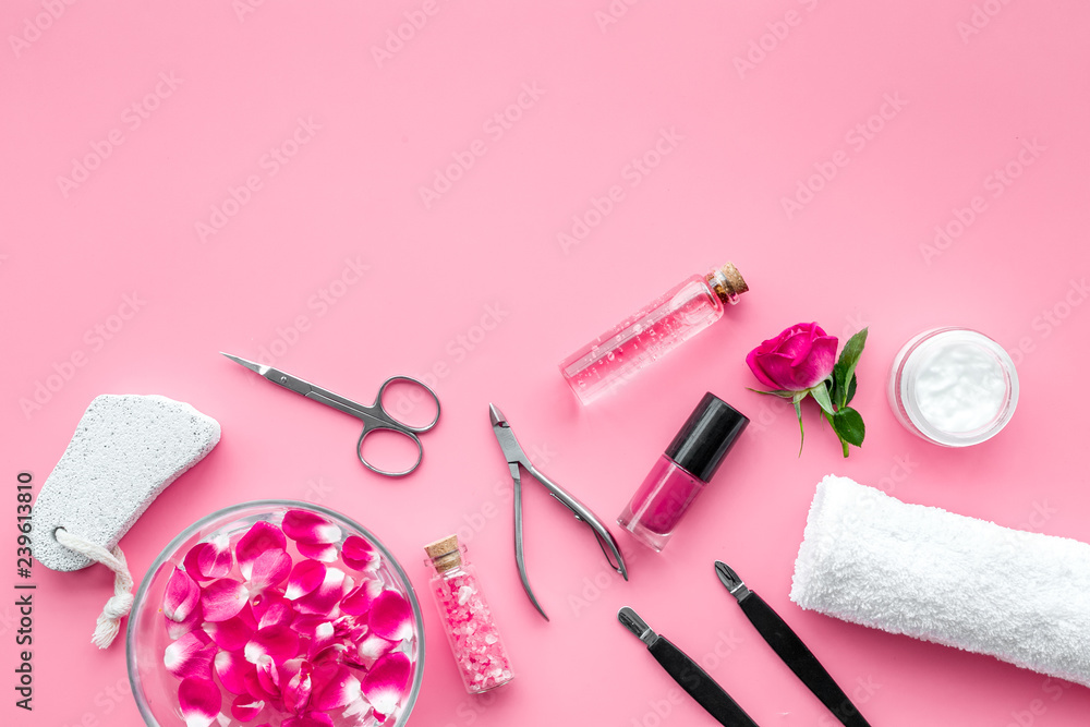Fototapeta premium manicure equipment with nail polish and rose petals pink background top view space for text
