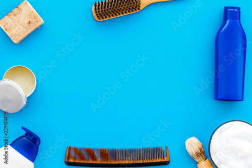 shampoo bottle and comb for man care in barbershop blue background top view mockup