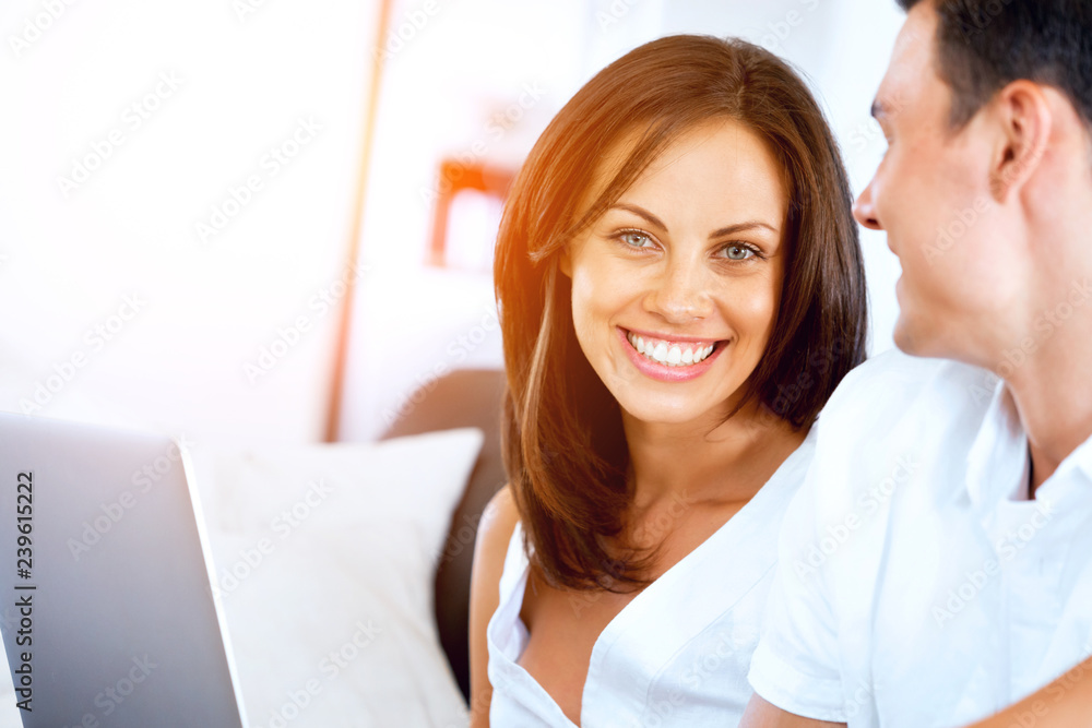 Happy modern couple working on laptop at home