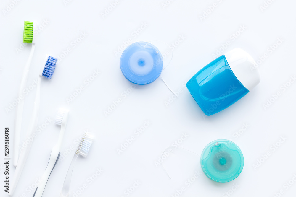 Tooth care with toothbrush, dental floss. Set of cleaning products for teeth on white background top view Tooth care with toothbrush, dental floss. Set of cleaning products for teeth on white background top view