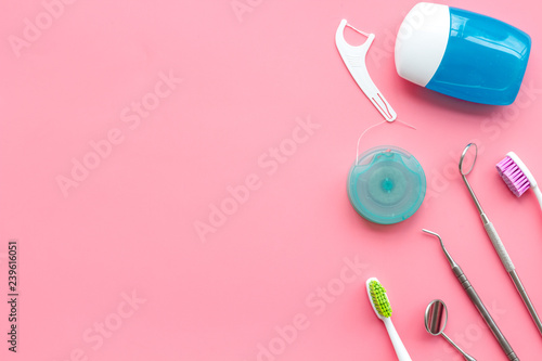 Daily oral hygiene for family. Toothbrush, dental floss and dentist instruments on pink background top view mock up