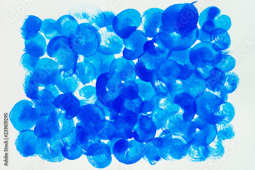Blue painted on white paper. Abstract background.