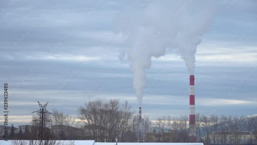 Smoky factory pipes with acrid smoke in the winter. The standard problem of pollution of the environment and air. Smoky factory pipes with acrid smoke in the winter. The standard problem of pollution of the environment and air.