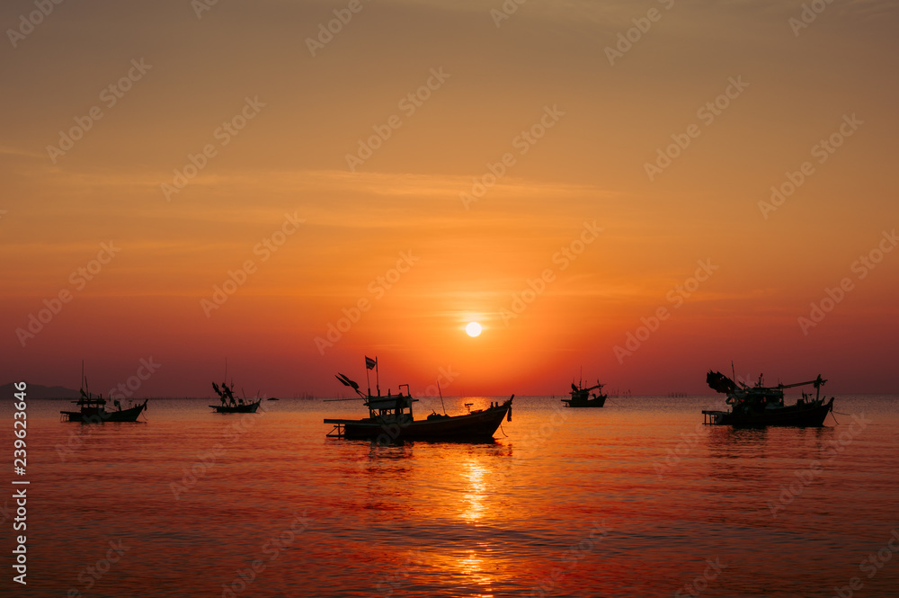 fishing boat at sunset on the beach.