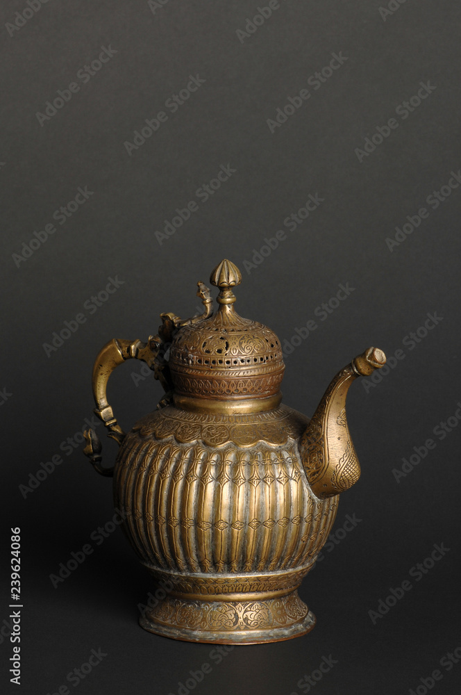 ancient oriental metal teapot on dark background. antique bronze tableware ancient oriental metal teapot on dark background. antique bronze tableware