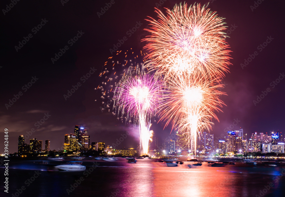 Beautiful fireworks shine on the sea with view of skyscrapers, Night sky with colorful fireworks above seascape view, Pattaya International Fireworks Festival 2018, Pattaya, Thailand, Tall building