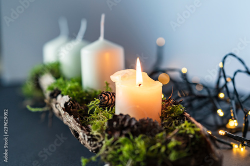 advent christmas wreath with 4 candels and the first candel burning