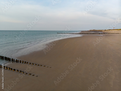 Menschenleerer Strand an der Nordsee bei Sonnenschein (Luftaufnahme, Drohne)