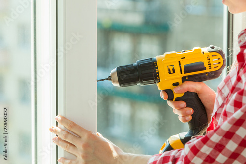 Person using drill on window