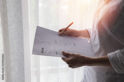young business woman in white shirt filling resume form, concept of find job at home.