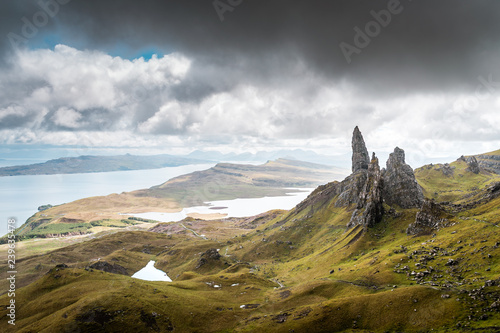 Old Man Of Storr Pinnacles, Scottland, Isle Of Skye - Picturesque mountain backdrop of the Scottish hiking paradise with spectacular rock formation surrounded by lush highland grass