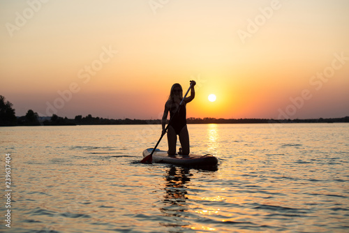 Young sexy woman swimming on stand up paddle board.Water sports , active lifestyle. 
