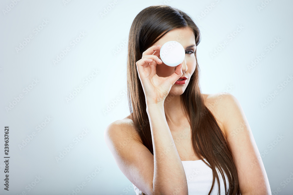 Beauty portrait of young woman holding skin care product.